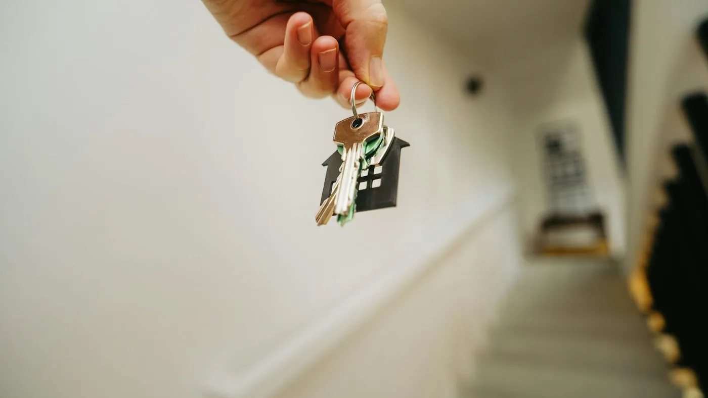 Main tenant un trousseau de clés dans l’entrée d’un logement
