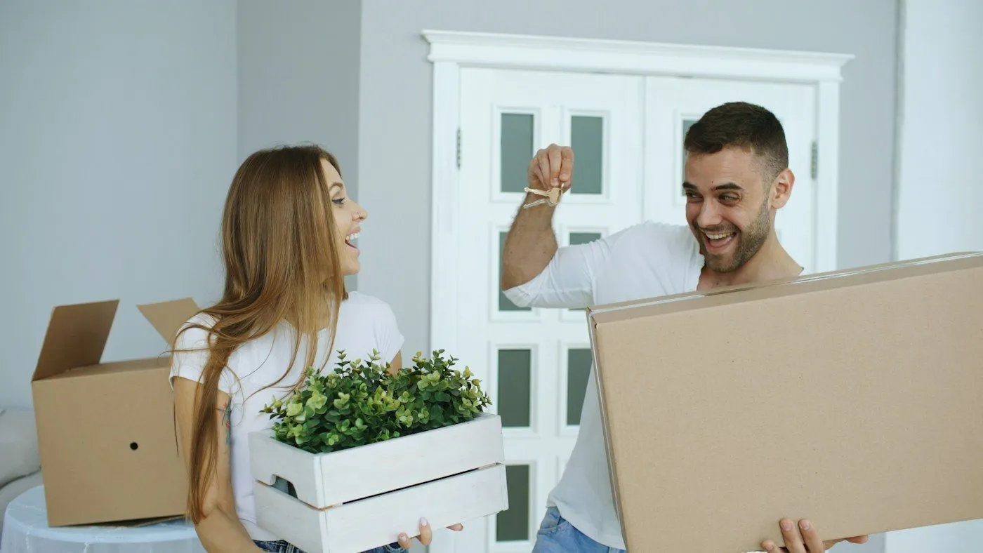 Couple portant des cartons de déménagement