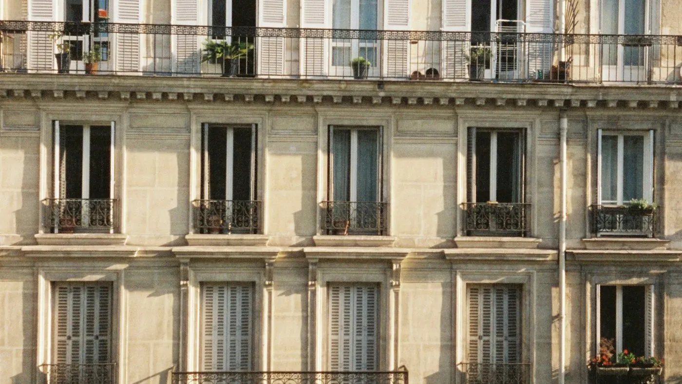 Façade d’immeuble ancien en pierre de taille avec balcons en fer forgé